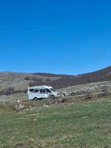 a white camper van parked in a field at Autocamp Kotari in Plužine