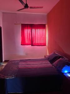 a bedroom with a bed with a red window at Sumanya guest house 3 in Sukuta