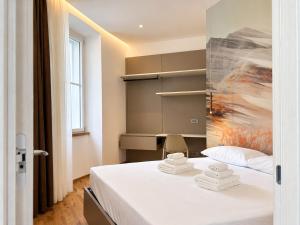 a room with a bed with a chair and a painting at Luxury Lodge - Moderno Residence vicino alla Stazione in Trieste