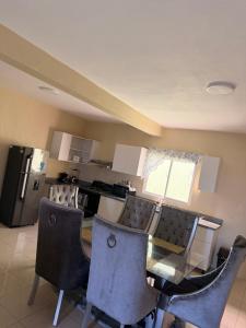 a kitchen with a glass table and chairs and a refrigerator at Edificio Ramírez 1 in Boca Canasta