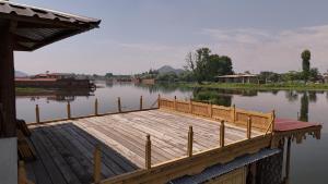 a dock on a lake with a boat in the water at Lord Palace Houseboat in Srinagar