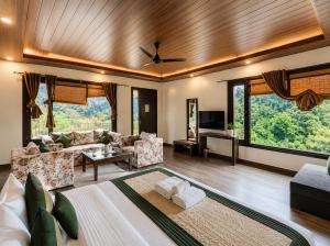 a living room with a couch and a tv at Skywood by Vankuteer - Pool & Mountain view Rooms in Kandāghāt