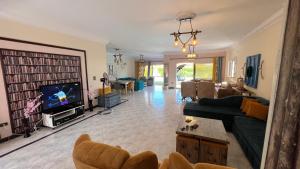 a living room with a couch and a tv at Caribiano villa-3 in Dawwār Ḩalīs