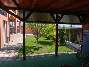 a screened in porch with a view of a yard at Casa Valentin in Corbu