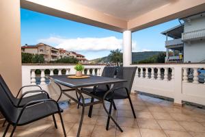 a patio with a table and chairs on a balcony at Apartments Gurman in Rab