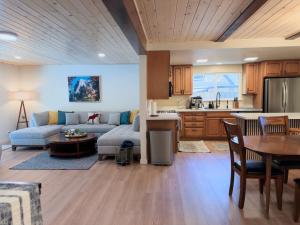 a kitchen and living room with a couch and a table at Pine Haven Tahoe-Cabin with Fire Pit, Grill & EV Charger in South Lake Tahoe