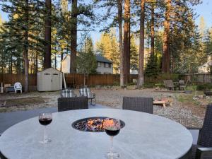a table with two glasses of red wine on it at Pine Haven Tahoe-Cabin with Fire Pit, Grill & EV Charger in South Lake Tahoe