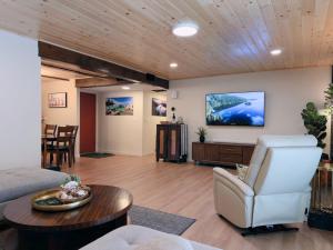 a living room with a couch and a tv at Pine Haven Tahoe-Cabin with Fire Pit, Grill & EV Charger in South Lake Tahoe