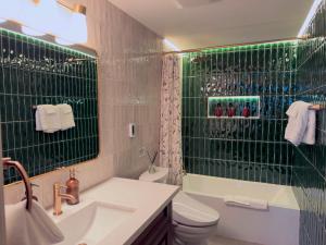a bathroom with a sink and a toilet and a shower at Pine Haven Tahoe-Cabin with Fire Pit, Grill & EV Charger in South Lake Tahoe +16 photos