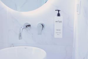 ein Badezimmer mit Waschbecken und Seifenspender in der Unterkunft Tinamar Selections in Perivolos