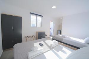 ein Schlafzimmer mit zwei Betten und einem Spiegel in der Unterkunft Tinamar Selections in Perivolos + 39 Fotos