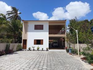 a white house with a stone driveway at Pousada Biana Residence in Santo Amaro