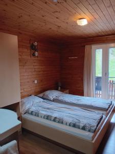 a bedroom with a bed in a wooden cabin at Pension Waldegg Zermeiggern in Saas-Almagell