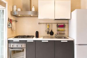 a kitchen with white cabinets and a stove top oven at Rooftop Madreperla in Taranto +9 photos