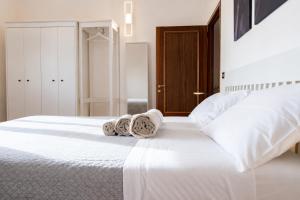 a bedroom with a white bed with towels on it at Rooftop Madreperla in Taranto