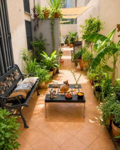 a patio with a table and a bench and plants at Guglielmo room's B&B in Catania