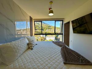 a bedroom with a bed with a large window at Panoramic view apartment with Pool and Rooftop in San Salvador +60 photos