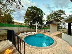a swimming pool in a backyard with chairs around it at Panoramic view apartment with Pool and Rooftop in San Salvador