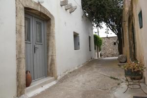 an alley with a door in a white building at studio Barbouni in Aroniadika
