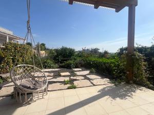 a patio with a swinging chair on a patio at הבית של טלי in Kfar Yehezkel