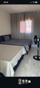 a bedroom with two beds next to a window at Casa Sol e mar in Tibau