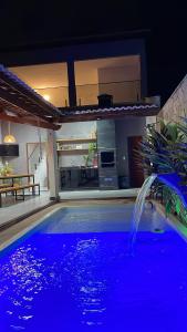 a swimming pool with a fountain in front of a house at Casa Sol e mar in Tibau +9 photos