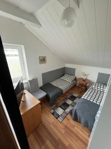 a attic room with two beds and a table at Noclegi U Waldiego in Starachowice