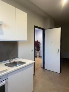 a white kitchen with a sink and a door at THE PORT Guest Rooms in San Ferdinando +7 photos