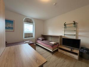 a living room with a table and a tv at Business Unterkunft Balje 567 - Monteur- & Ferienwohnung mit 7 Einzelbetten in Balje