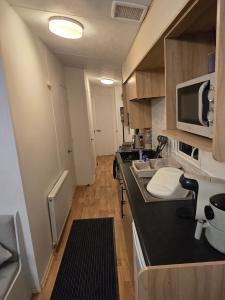 a small kitchen with a sink and a microwave at D&D Getaways in Hull