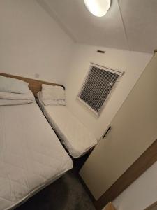 a small room with two beds and a window at D&D Getaways in Hull
