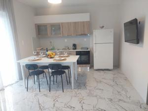 a kitchen with a table with chairs and a refrigerator at Claudia's Apartments in Aliveri