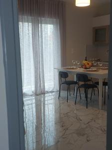 a dining room with a table and chairs and a kitchen at Claudia's Apartments in Aliveri