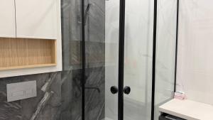 a shower with glass doors in a bathroom at Zafran Platinum Apartments in Dushanbe +25 photos