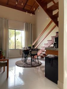 a living room with a table and chairs and a staircase at Estância Shangri-La in Santa Teresa