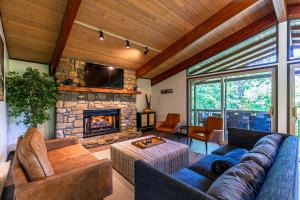 a living room with a couch and a stone fireplace at Chasing Birdies in Beech Mountain