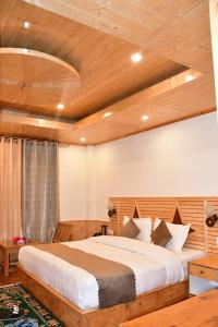 a bedroom with a large bed with a wooden ceiling at The sky walk in Manāli