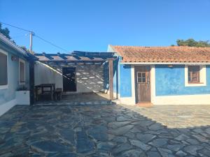 a house with a stone walkway next to a building at Suite no campo in Cercal