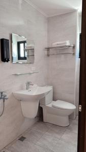 a white bathroom with a sink and a toilet at Musun Stay in Ch'ao-yang