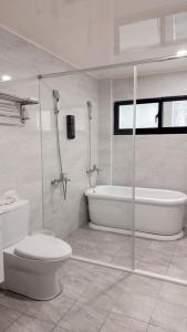 a bathroom with a tub and a toilet and a sink at Musun Stay in Ch'ao-yang