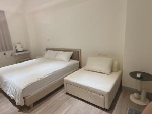 a small bedroom with two beds and a table at Musun Stay in Ch'ao-yang