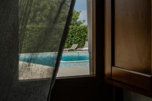 a view of a swimming pool through a window at Tre Balate Natura e Relax in Modica
