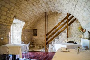 a dining room with two tables and a stone wall at Tre Balate Natura e Relax in Modica +62 photos