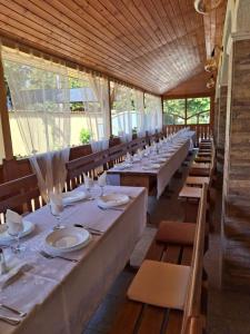 a long row of tables with plates and wine glasses at Cserki Panzió Balatonfőkajár in Balatonfőkajár