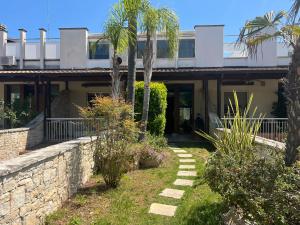 a house with palm trees and a stone wall at 5suitesuperior in Bari