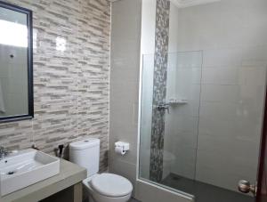 a bathroom with a toilet and a sink and a shower at Umayuri Inn in Ubud