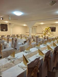 a banquet hall with white tables and chairs at Cserki Panzió Balatonfőkajár in Balatonfőkajár