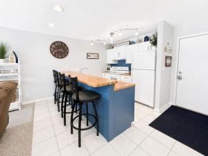 a kitchen with a blue island and black stools at Serenity Pointe Boat Slip in Osage Beach