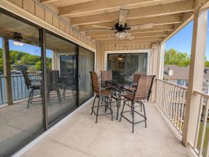 a screened porch with a table and chairs on it at Serenity Pointe Boat Slip in Osage Beach