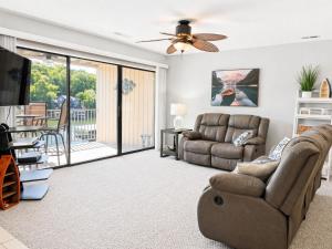 a living room with a couch and a ceiling fan at Serenity Pointe Boat Slip in Osage Beach